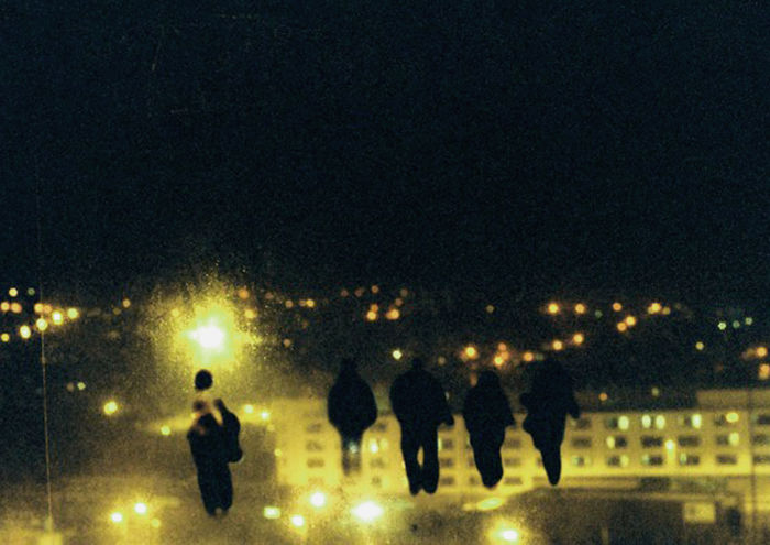 photograph of figures on acetate, stuck to a window and re-photographed on my window with view of city landscape at night