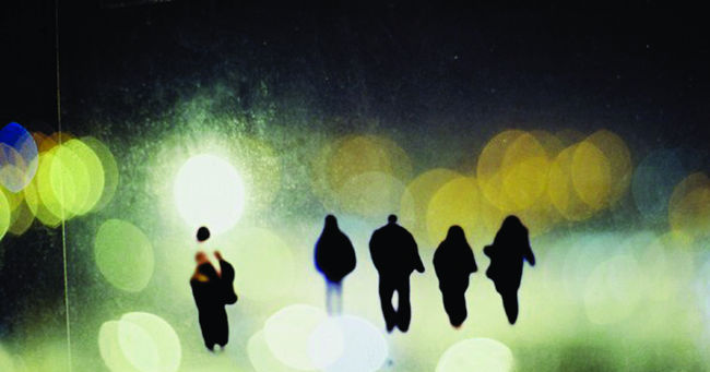 photograph of figures on acetate, stuck to a window and re-photographed on my window with view of city landscape at night