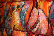 sections of the silk painting attached to the relief background with stitch and beaded work.